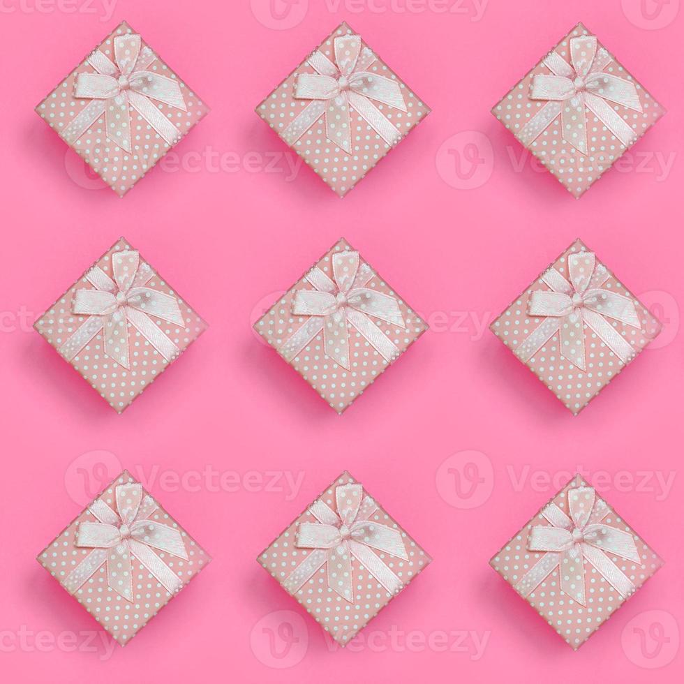 A lot of pink gift boxes lies on texture background of fashion pastel pink color paper in minimal concept. Abstract trendy pattern photo