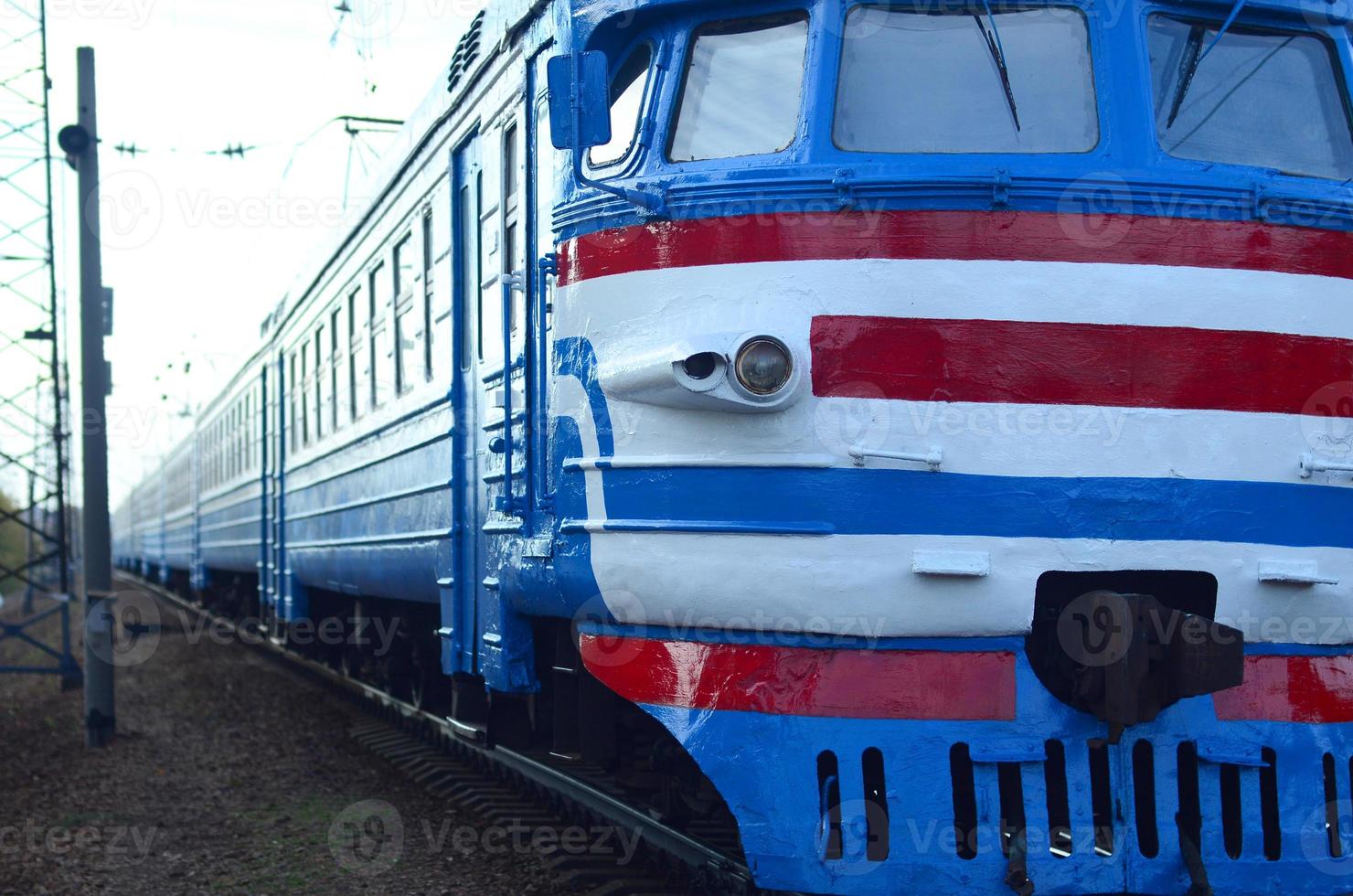 Old soviet electric train with outdated design moving by rail photo