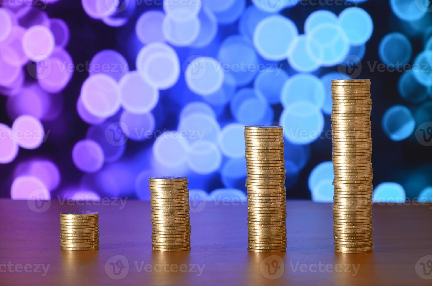 Golden coin stacks arranged as a graph. Increasing columns of coins photo