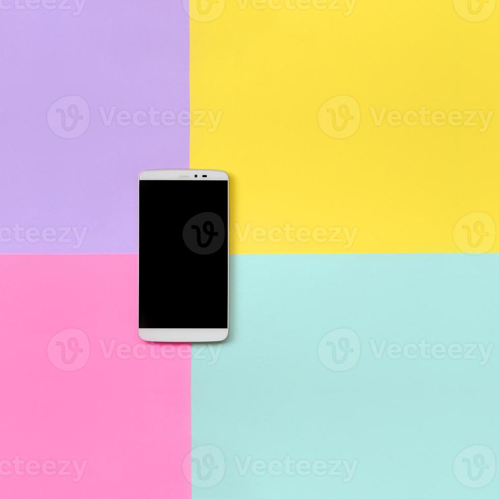 Modern smartphone with black screen on texture background of fashion pastel blue, yellow, violet and pink colors paper in minimal concept photo