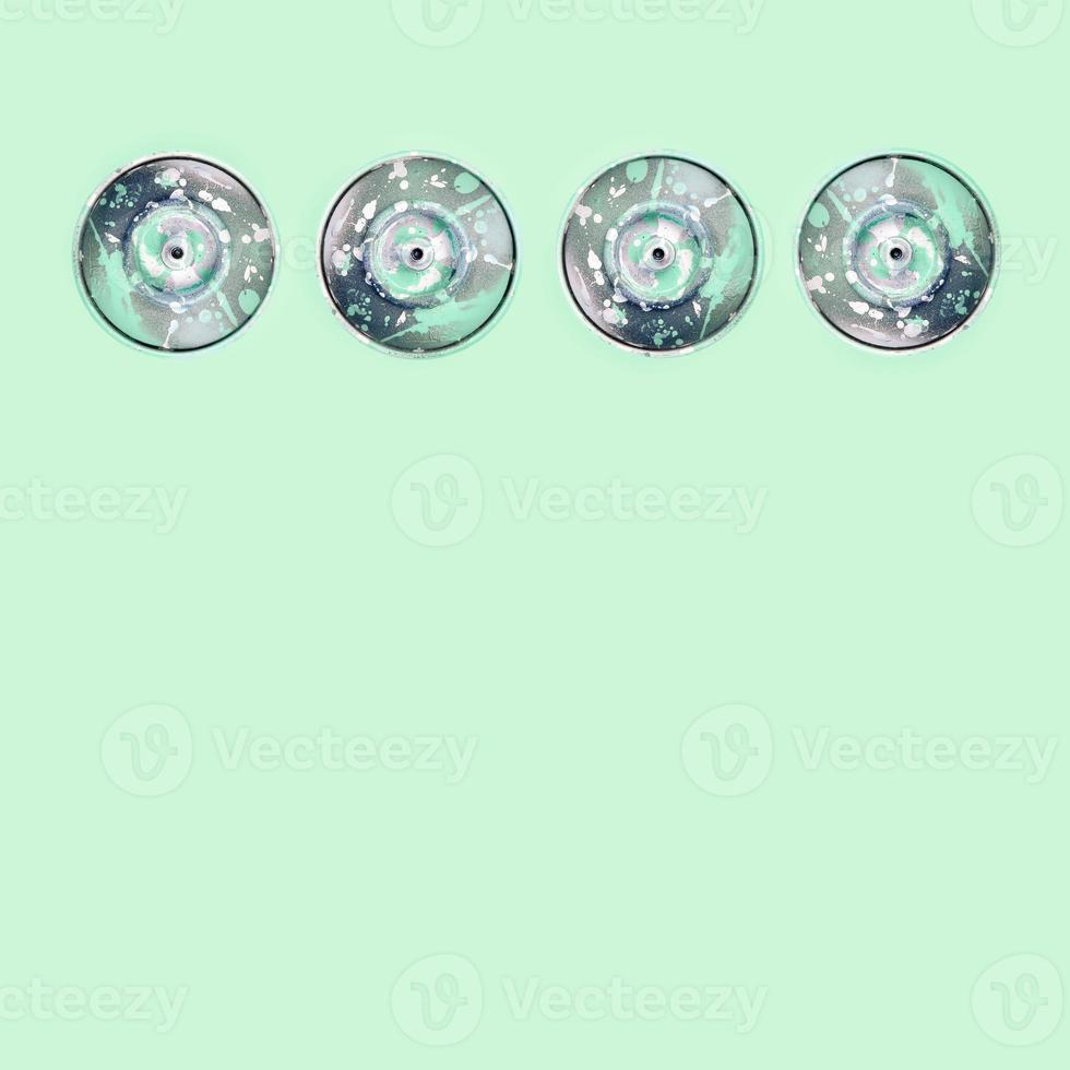Many used spray cans for graffiti drawing lies on a pastel colored backgroung. Street art painting concept. Minimal flat lay pattern. Top view photo