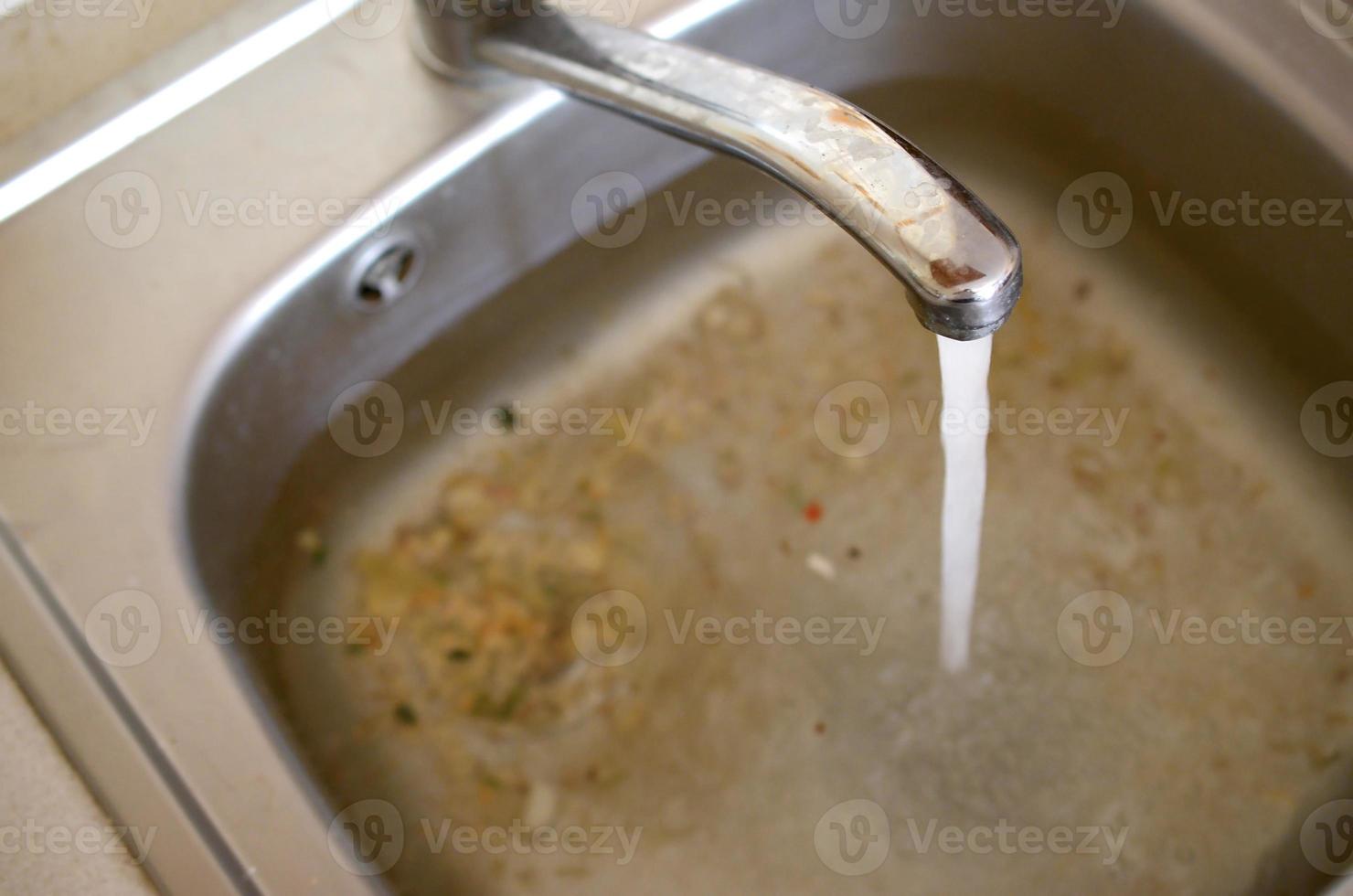 Stainless steel sink plug hole close up full of water and particles of food 14501861 Stock Photo