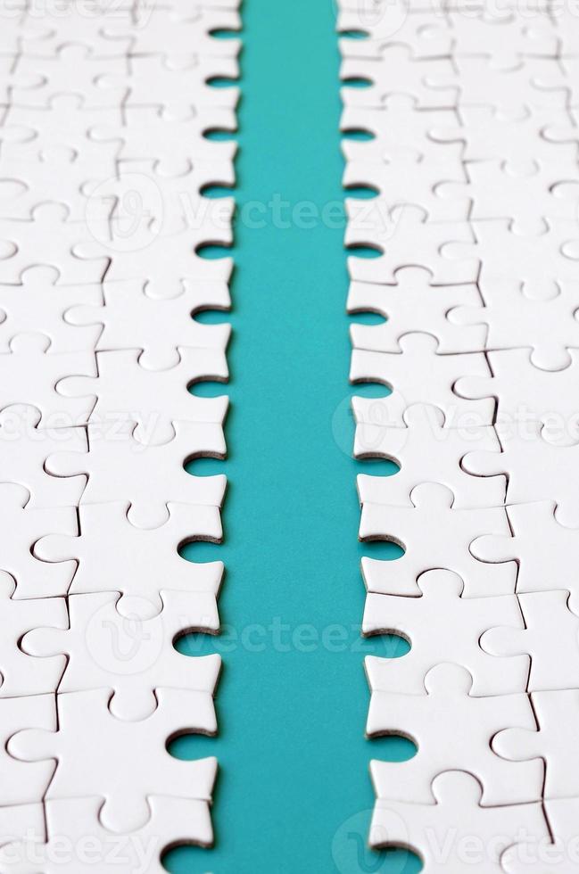 The blue path is laid on the platform of a white folded jigsaw puzzle. Texture image with copy space for text photo