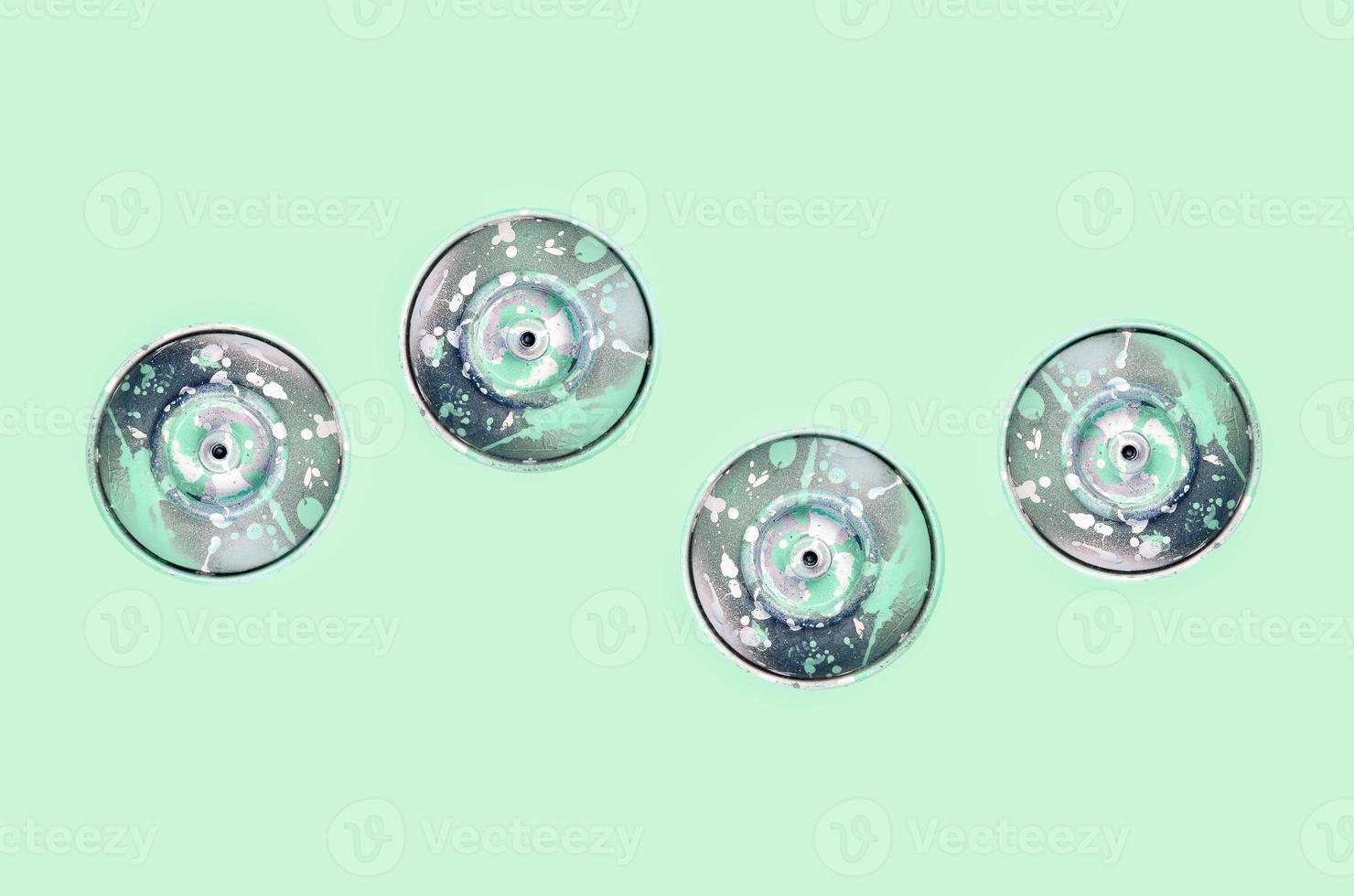 Many used spray cans for graffiti drawing lies on a pastel colored backgroung. Street art painting concept. Minimal flat lay pattern. Top view photo