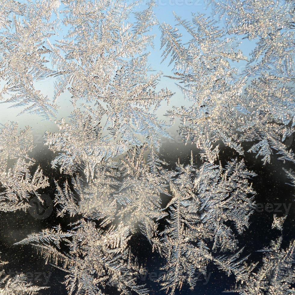 Snowflakes frost rime macro on window glass pane photo