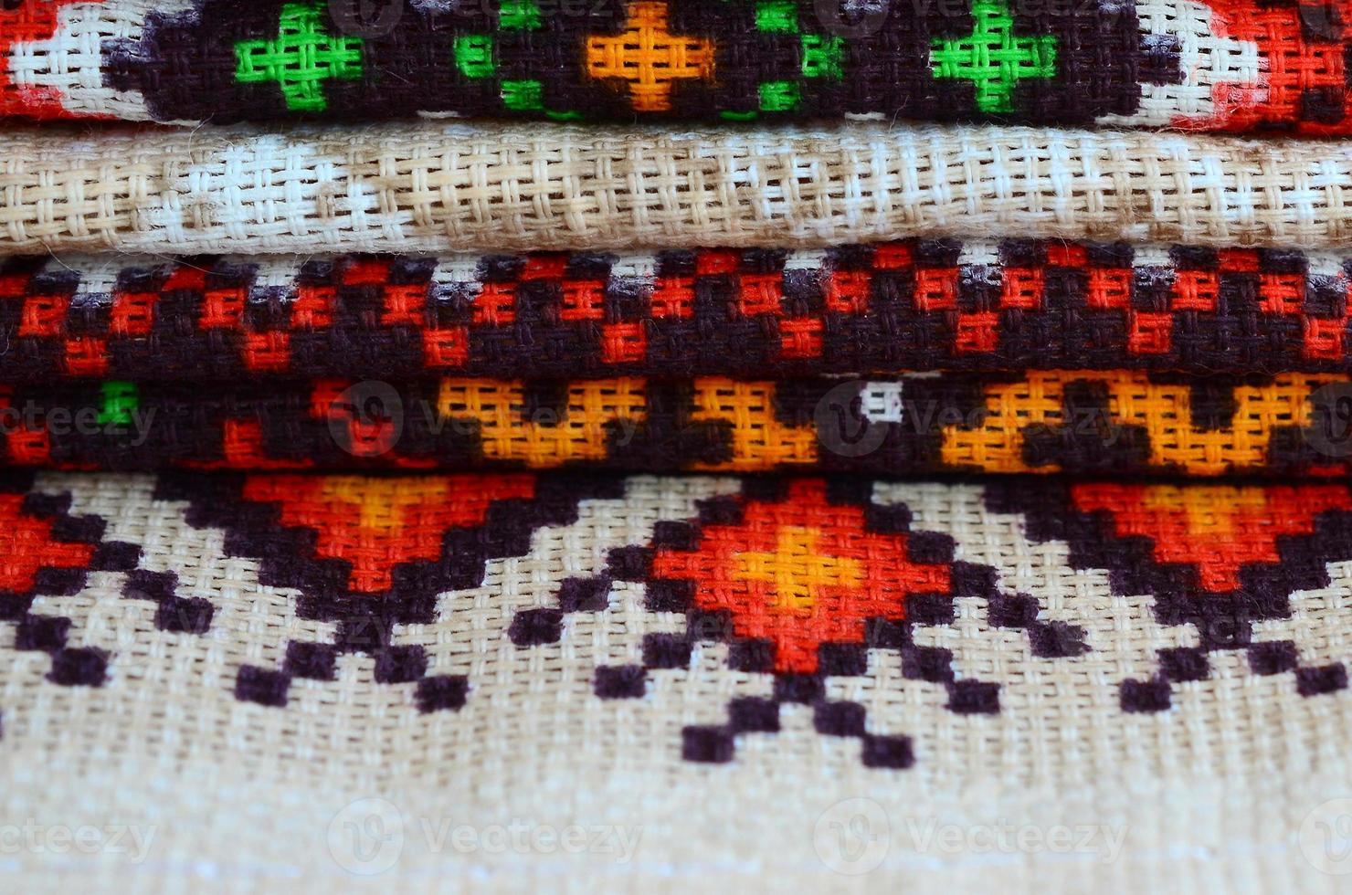 Stack of traditional Ukrainian folk art knitted embroidery patterns on textile fabric photo