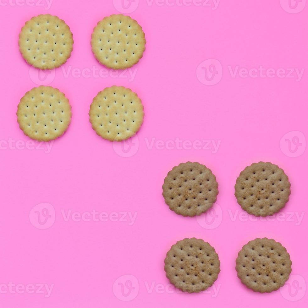 Pattern of a brown biscuits on a pink background. Trendy minimal concept of food and dessert. Abstract flat lay, top view photo