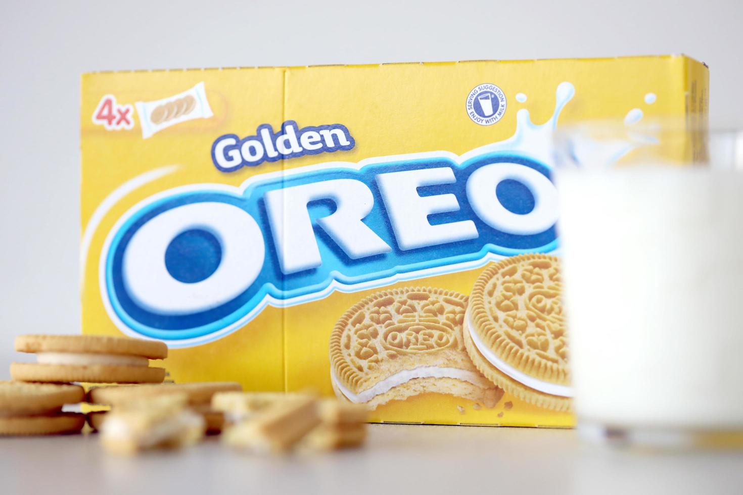 TERNOPIL, UKRAINE - MAY 28, 2022 Oreo golden crispy cookies with glass of milk on white background. The brand Oreo is owned by company Mondelez international photo