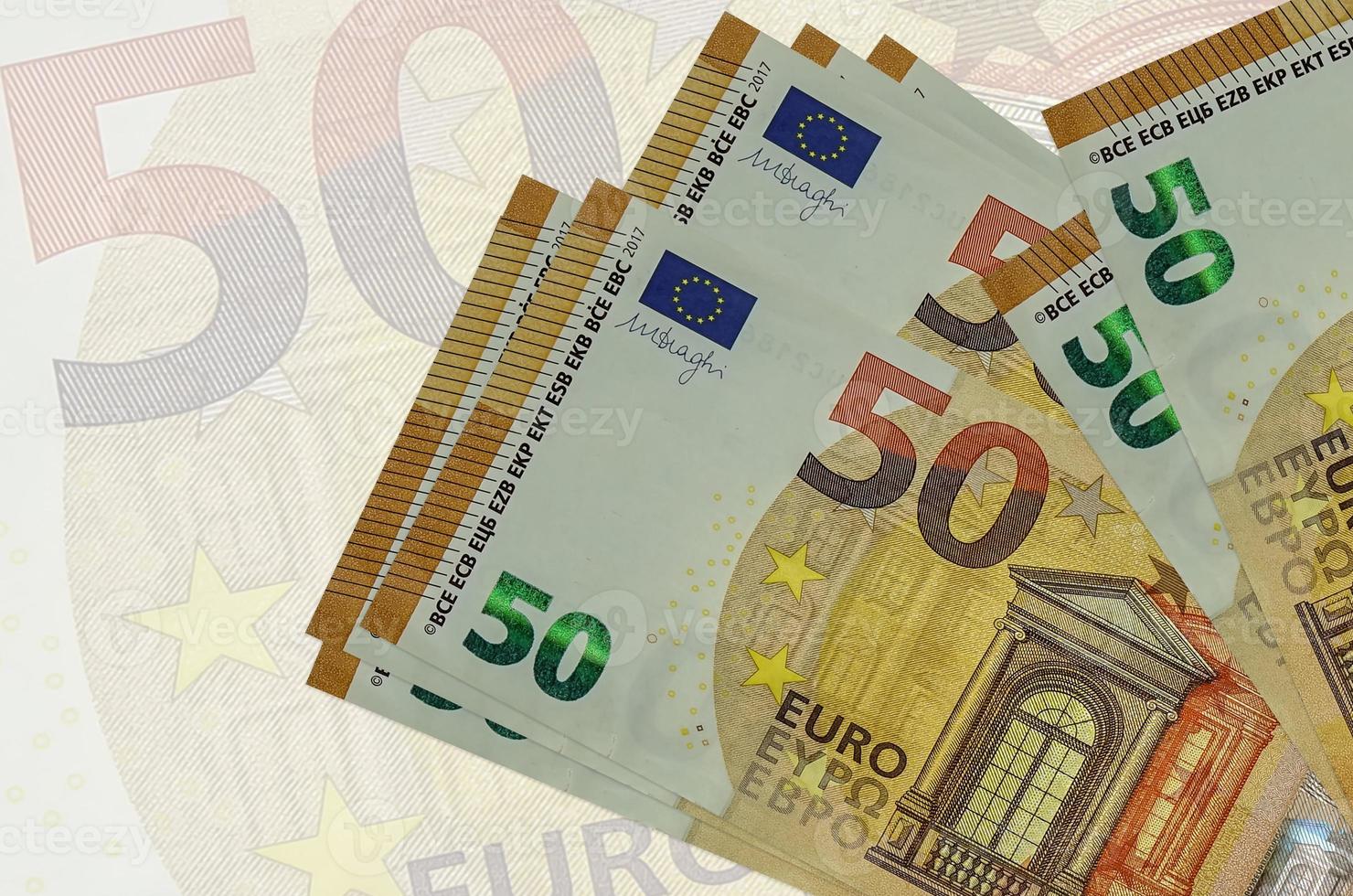 50 euro bills lies in stack on background of big semi-transparent banknote. Abstract presentation of national currency photo