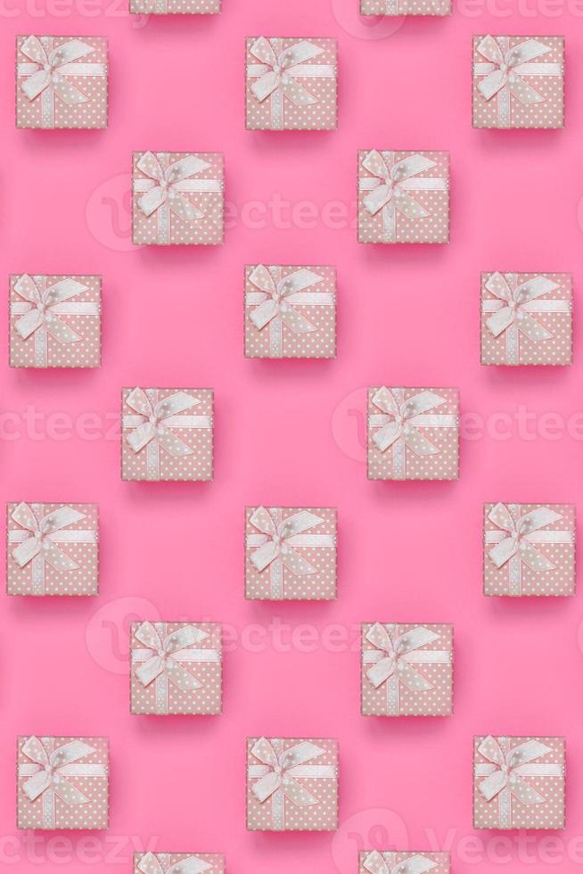 un montón de cajas de regalo rosas se encuentran en el fondo de textura de papel de color rosa pastel de moda en un concepto mínimo. patrón abstracto de moda foto