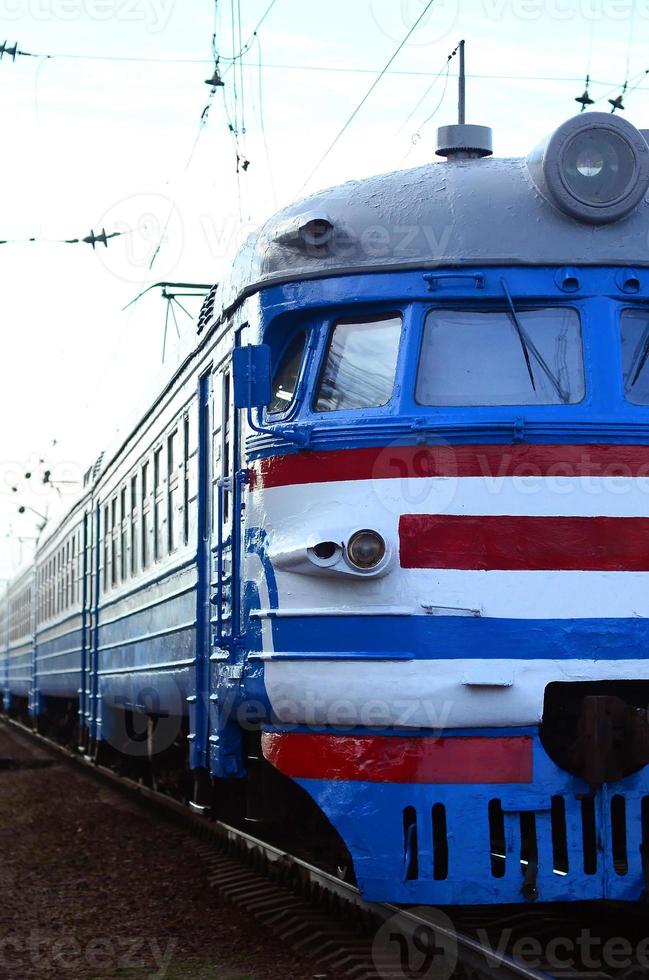 Old soviet electric train with outdated design moving by rail photo