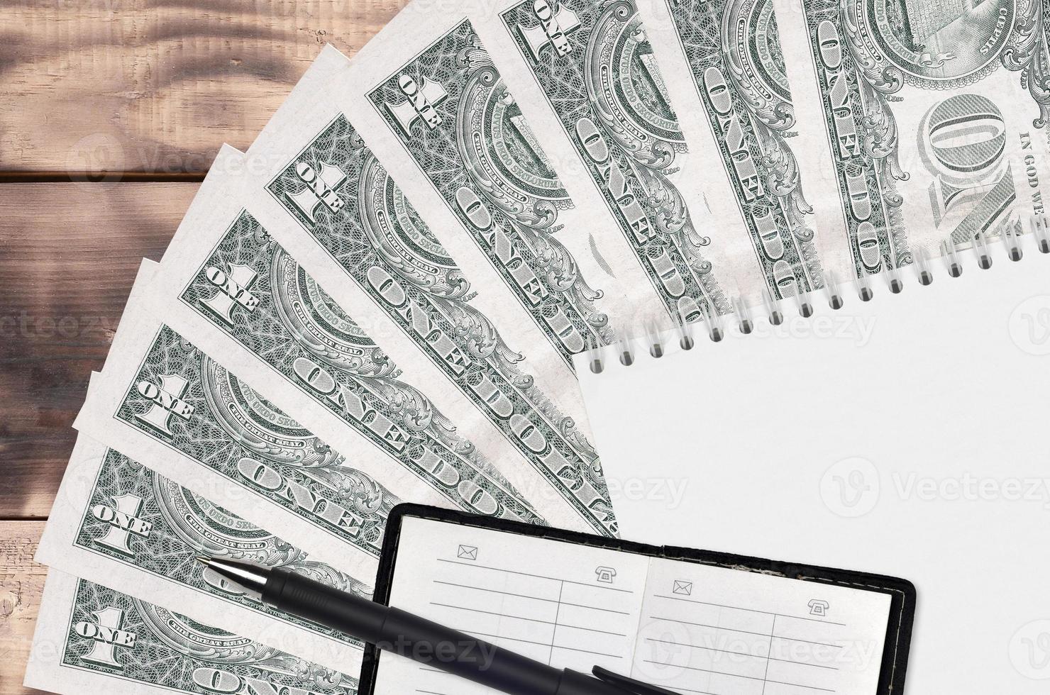 1 US dollar bills fan and notepad with contact book and black pen. Concept of financial planning and business strategy photo