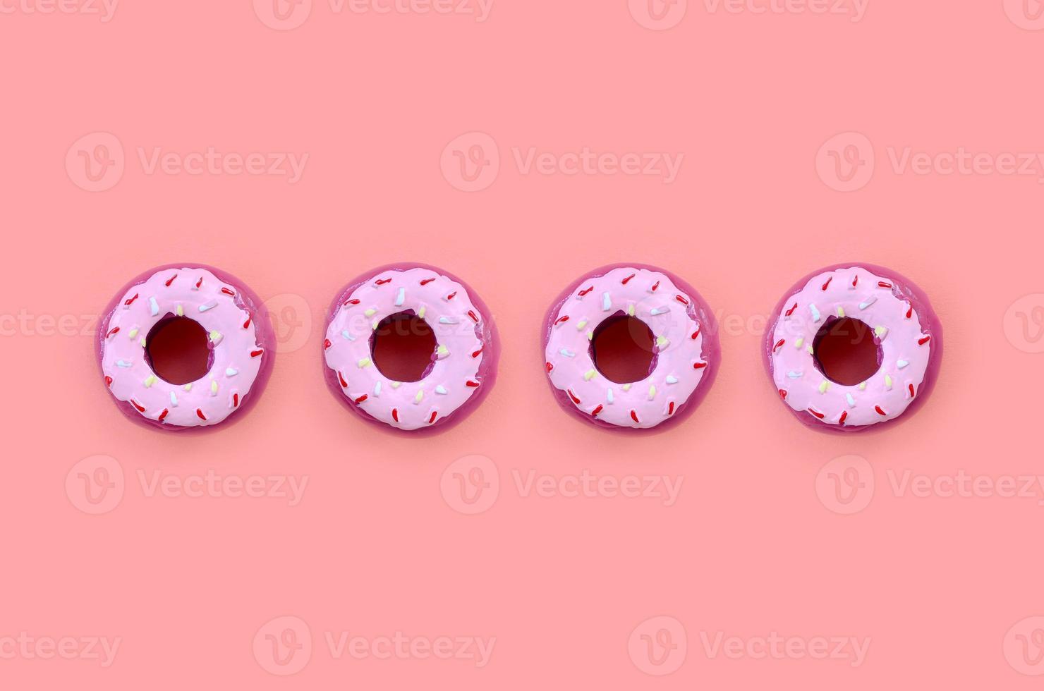Many small plastic donuts lies on a pastel colorful background. Flat lay minimal pattern. Top view photo