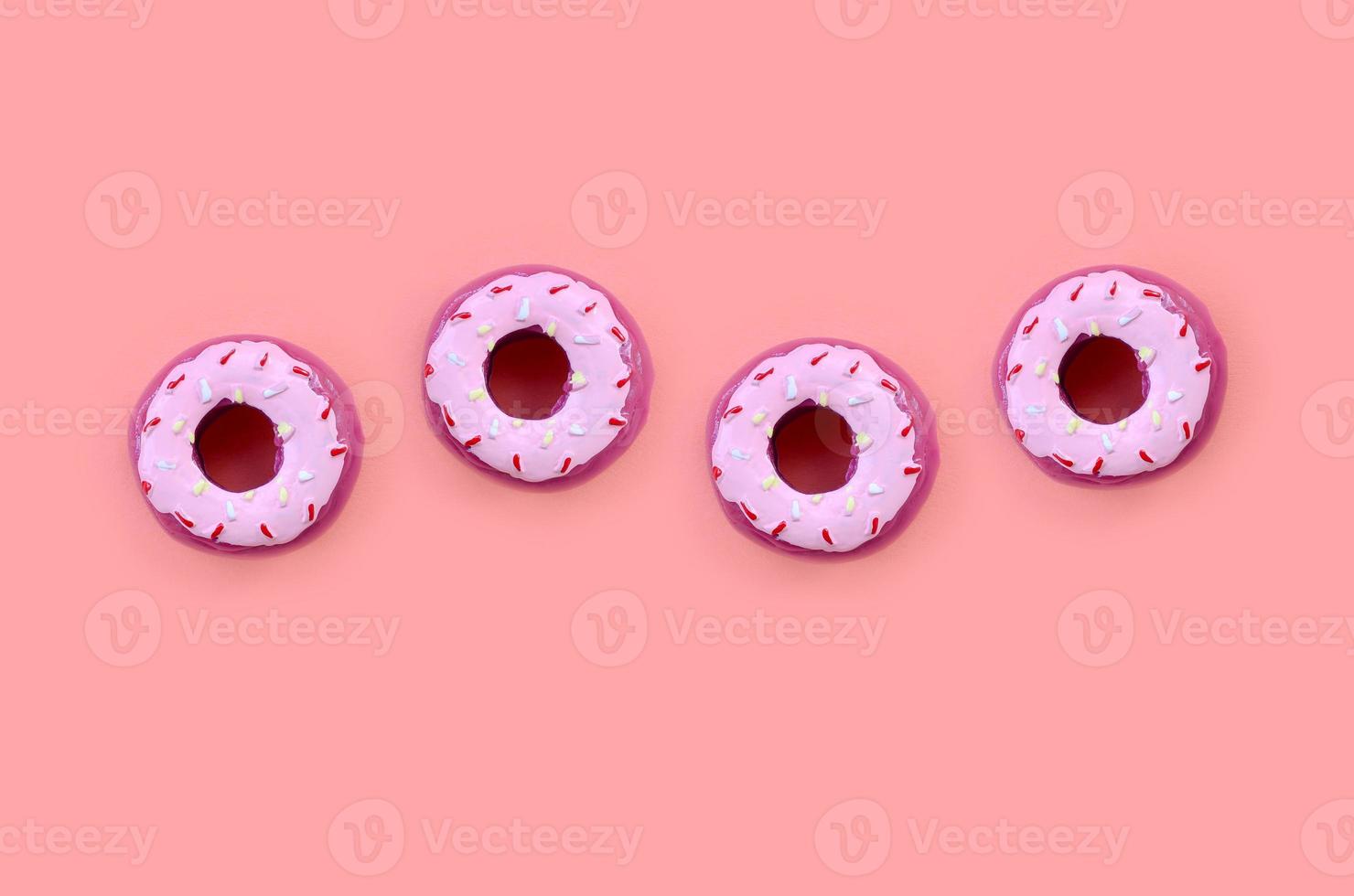 Many small plastic donuts lies on a pastel colorful background. Flat lay minimal pattern. Top view photo