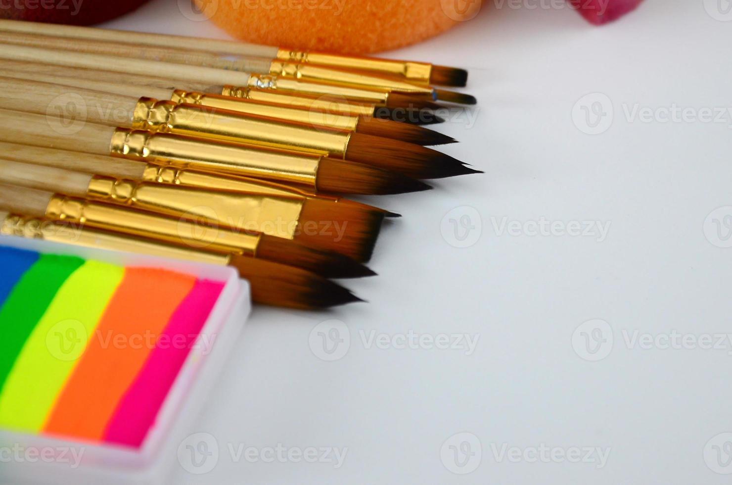 Color cosmetics, brushes and sponges for face painting on white background photo