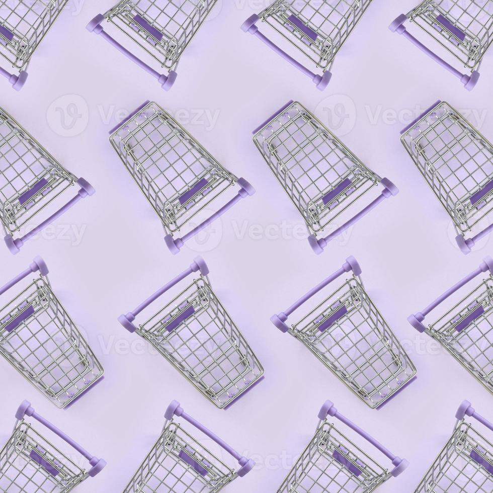 Pattern of many small shopping carts on a violet background. Minimalism flat lay top view photo