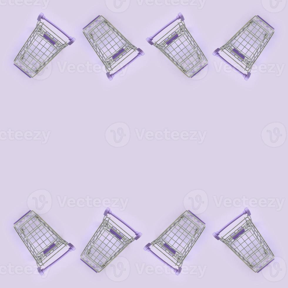 Pattern of many small shopping carts on a violet background. Minimalism flat lay top view photo