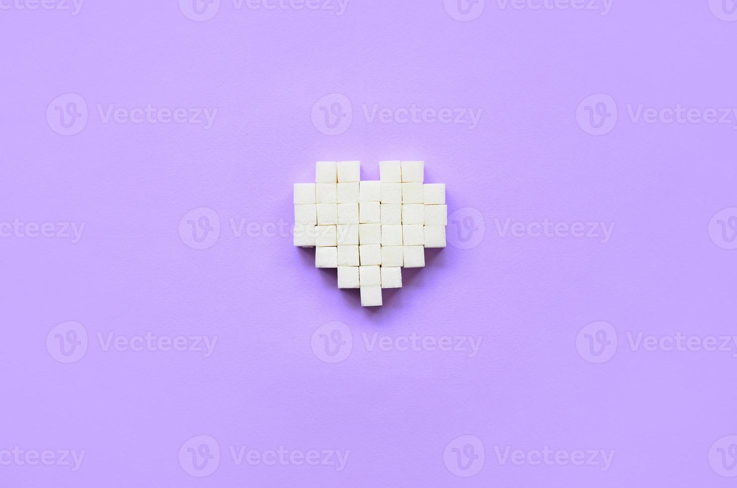 un corazón hecho de cubos de azúcar yace sobre un moderno fondo violeta pastel foto