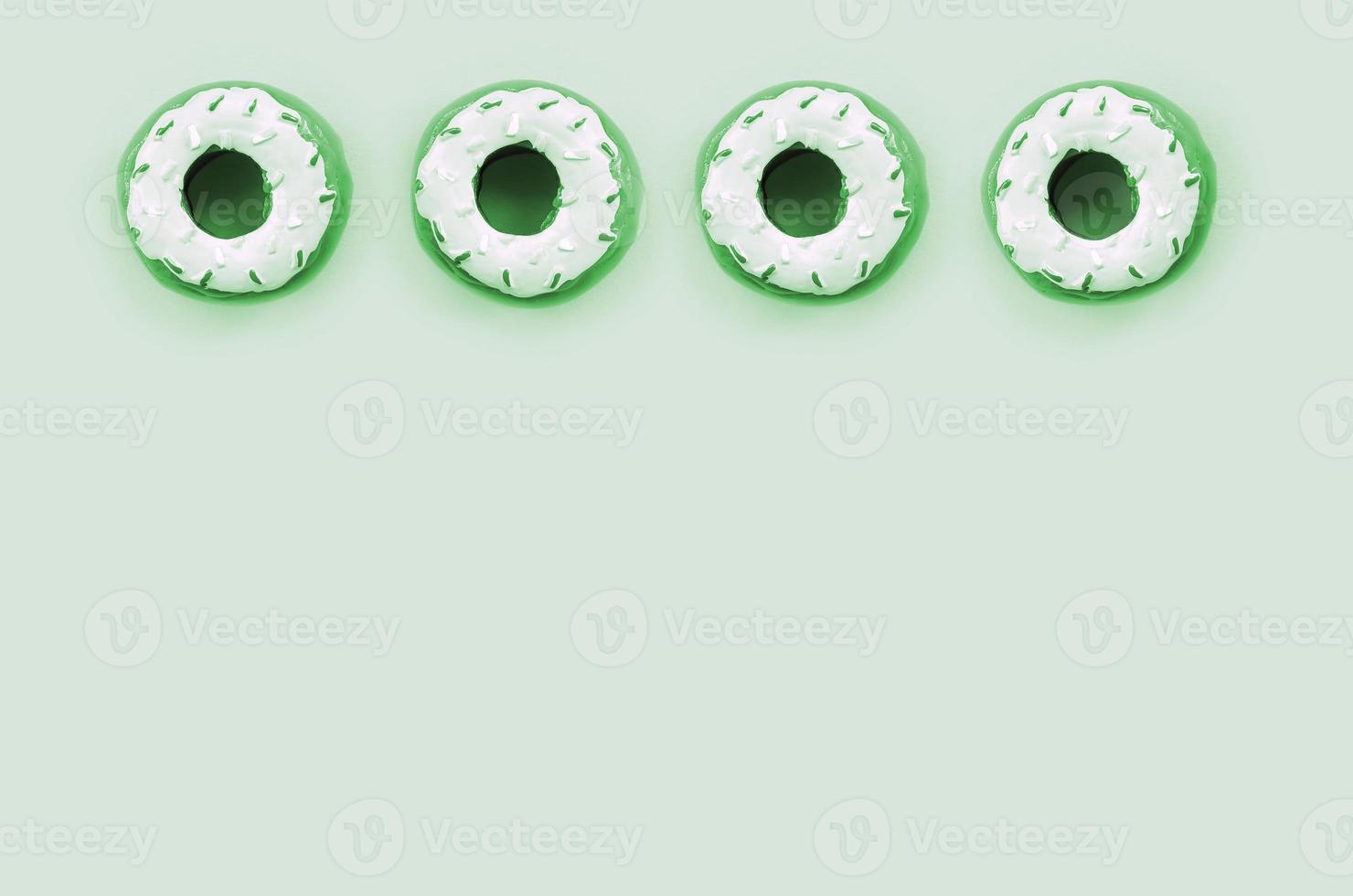Many small plastic donuts lies on a pastel colorful background. Flat lay minimal pattern. Top view photo