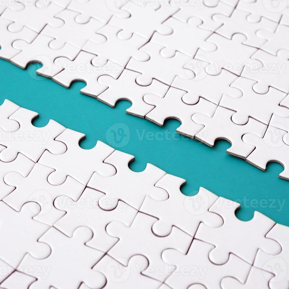 The blue path is laid on the platform of a white folded jigsaw puzzle. Texture image with copy space for text photo
