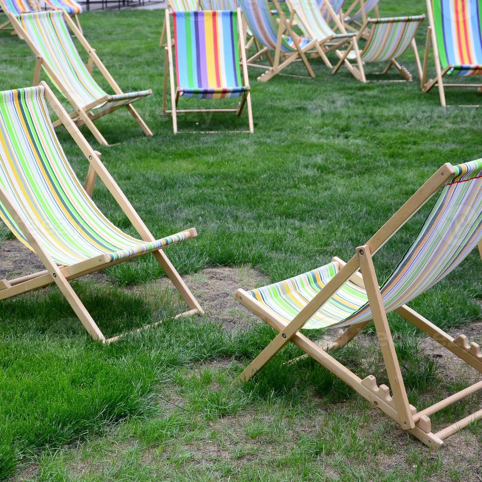 Chaise lounges on a lawn. Garden sunbeds on green grass photo