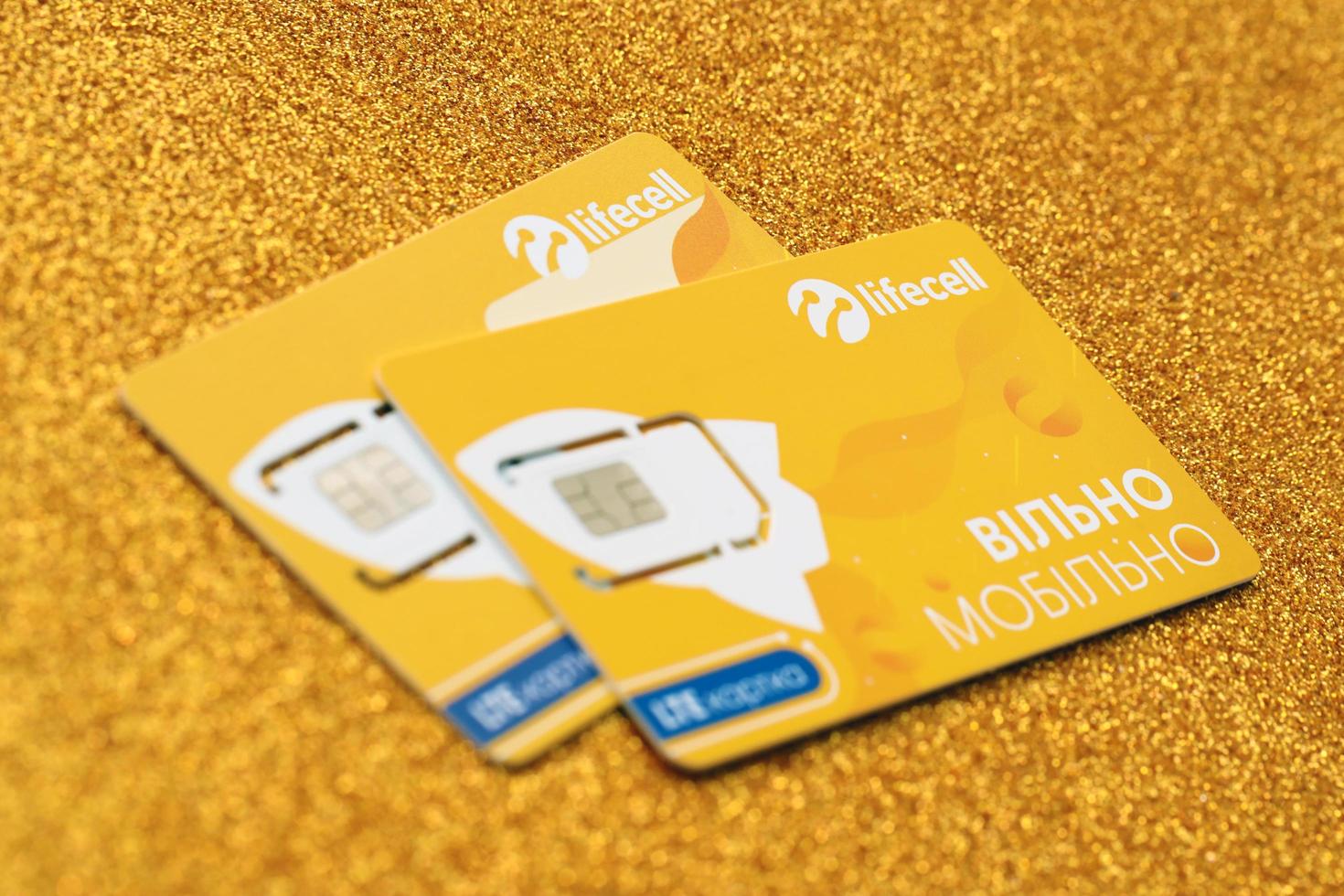 TERNOPIL, UKRAINE - JULY 5, 2022 Lifecell new sim card with free contract on yellow background. Lifecell is ukrainian mobile telephone network operator and provider of wireless connection photo