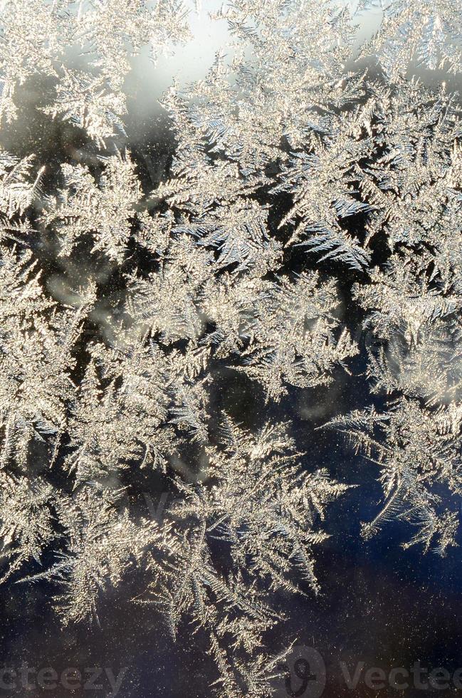 Snowflakes frost rime macro on window glass pane photo