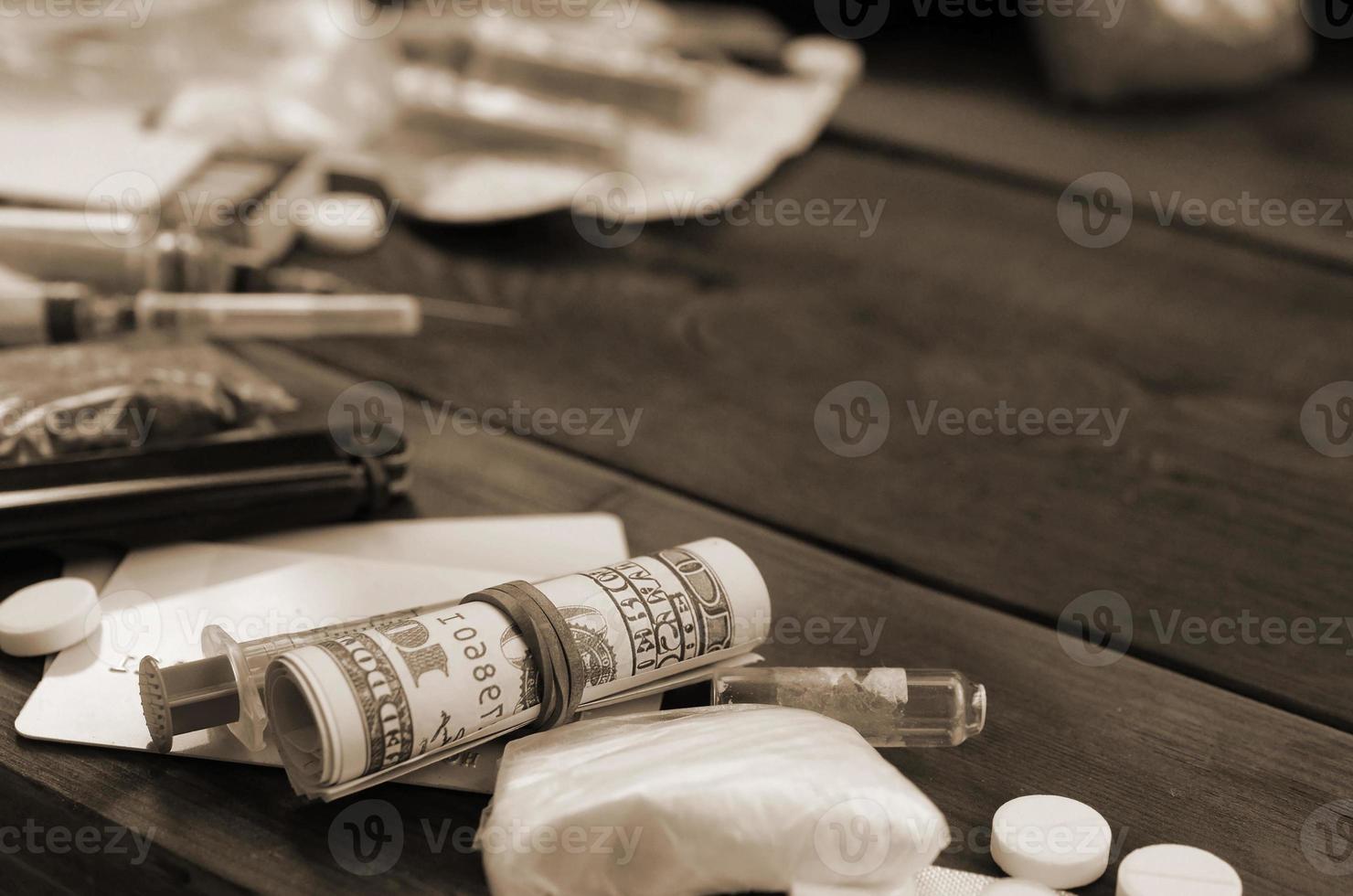 A lot of narcotic substances and devices for the preparation of drugs lie on an old wooden table photo