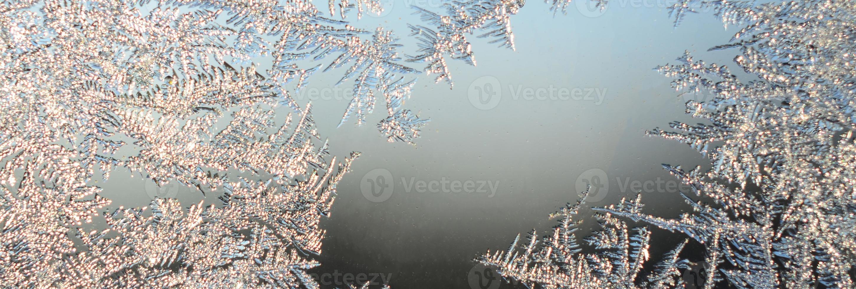 Snowflakes frost rime macro on window glass pane photo