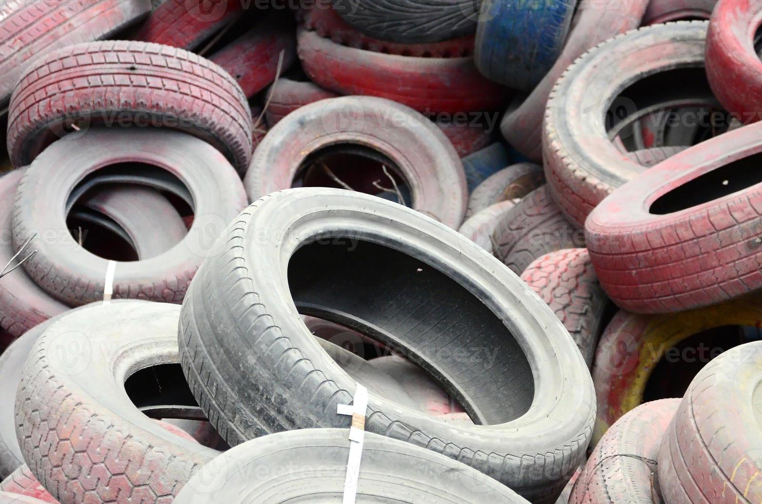 A picture of many old used tires left on a waste dump photo