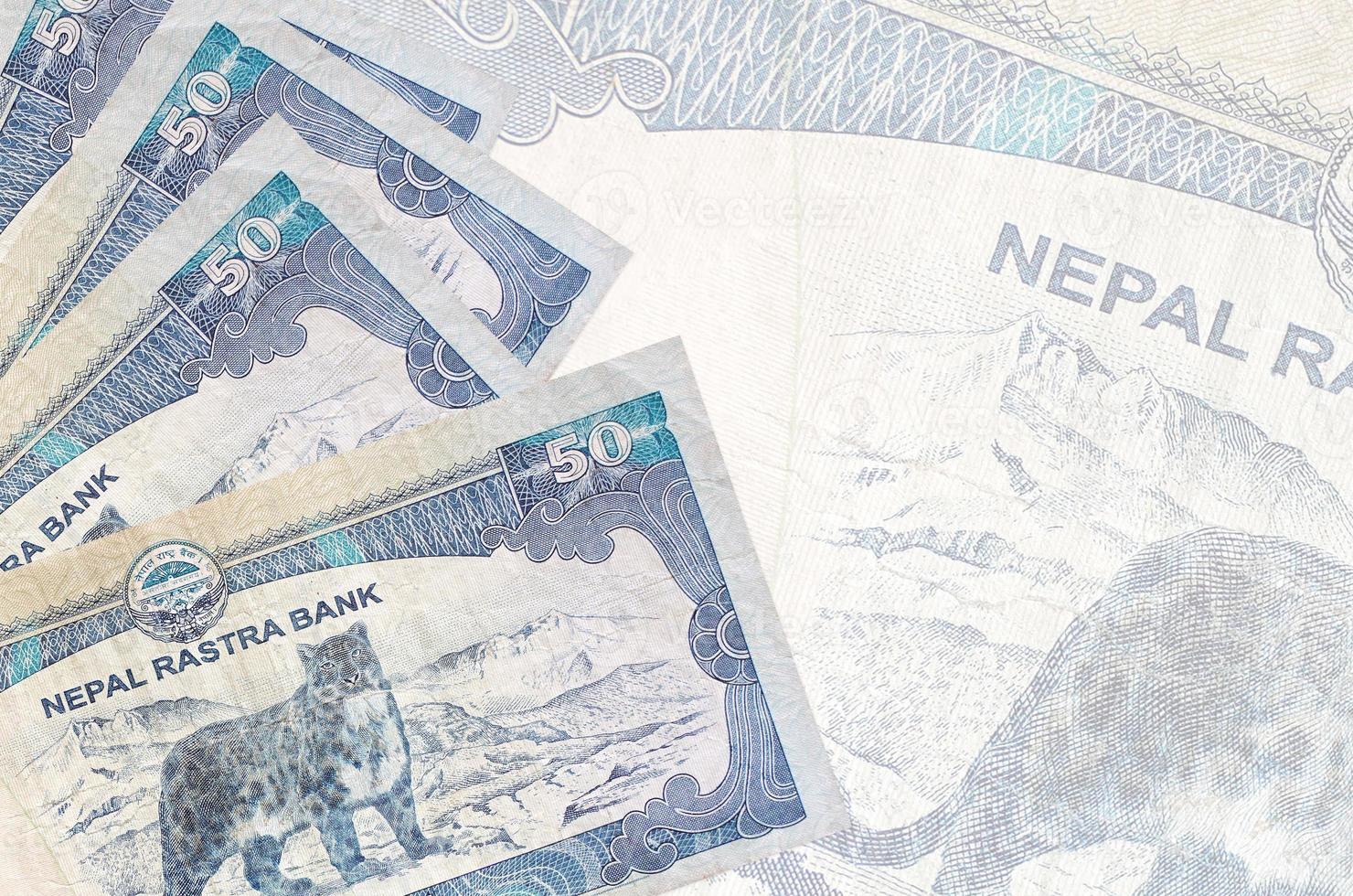 50 Nepalese rupees bills lies in stack on background of big semi-transparent banknote. Abstract business background photo