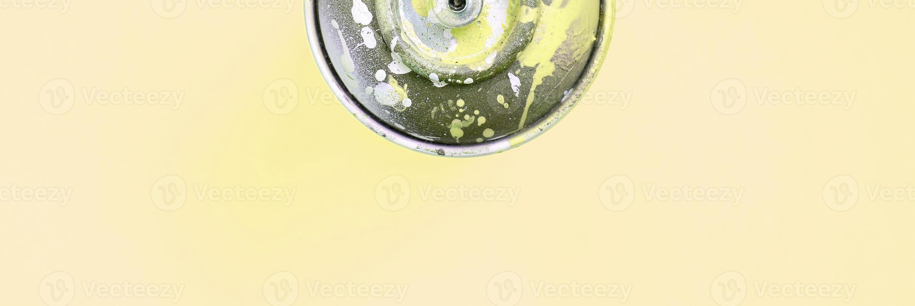 Single used spray can for graffiti drawing lies on a pastel colored backgroung. Street art painting concept. Minimal flat lay. Top view photo