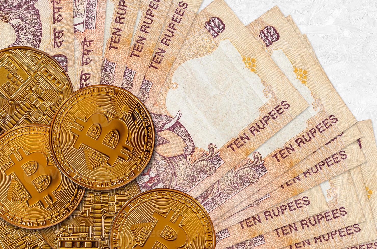 10 Indian rupees bills and golden bitcoins. Cryptocurrency investment concept. Crypto mining or trading photo