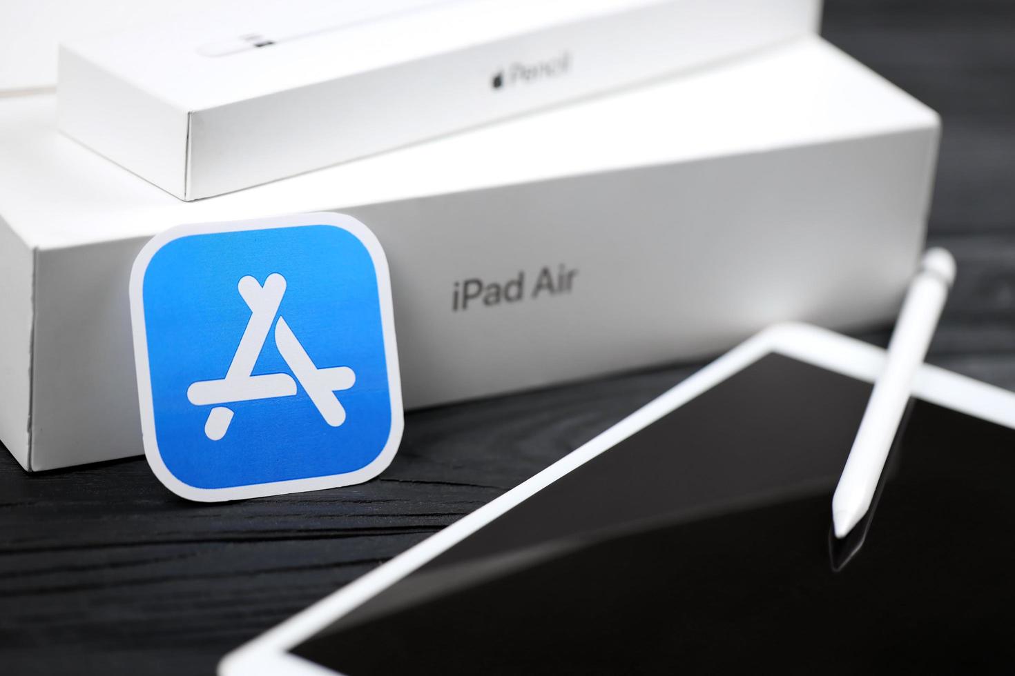 KHARKIV, UKRAINE - JANUARY 27, 2022 Brand new Apple iPad and Apple Pencil and blue app store logo on black background. Apple Inc. is an American technology company photo