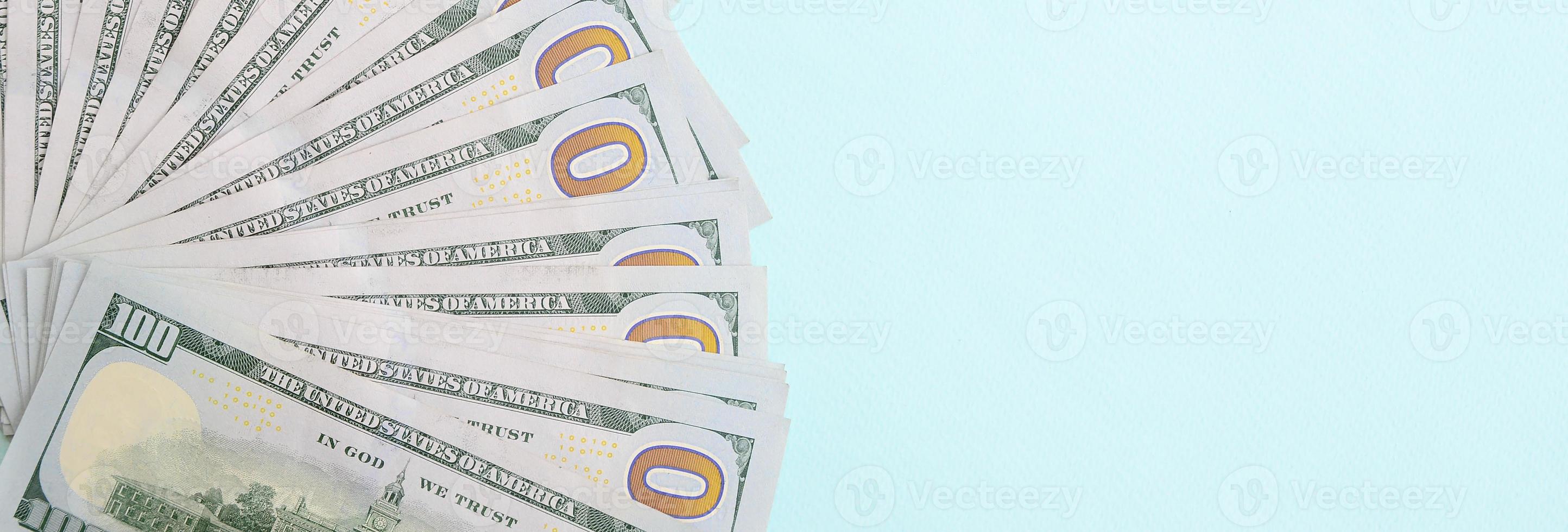 Fan of a US dollar bills of a new design lies on a light blue background photo