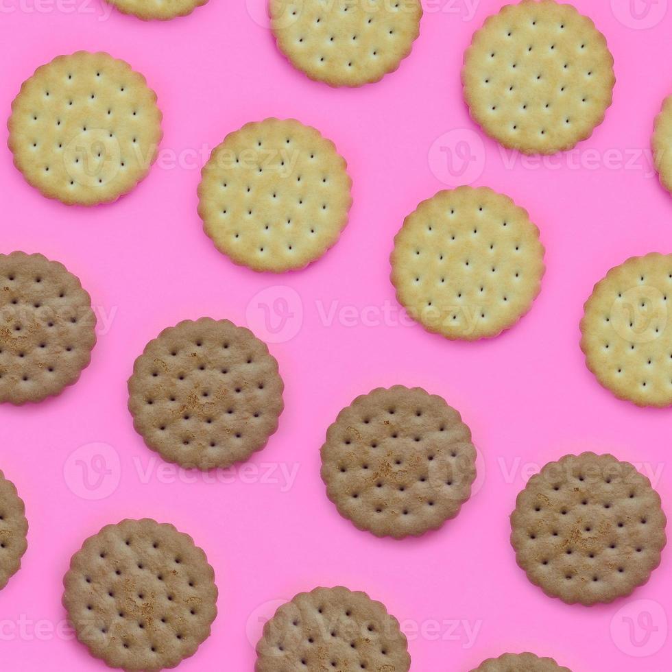 Pattern of a brown biscuits on a pink background. Trendy minimal concept of food and dessert. Abstract flat lay, top view photo