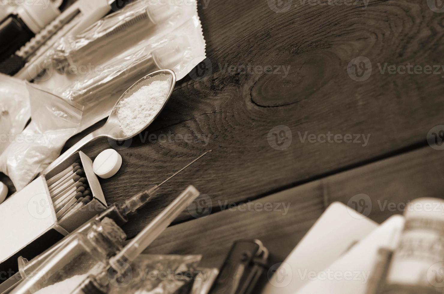 A lot of narcotic substances and devices for the preparation of drugs lie on an old wooden table photo
