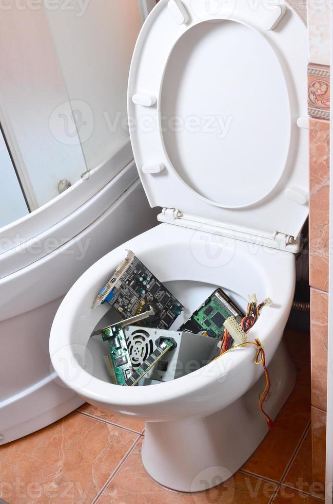 Old and unused computer details is recycled in toilet bowl photo