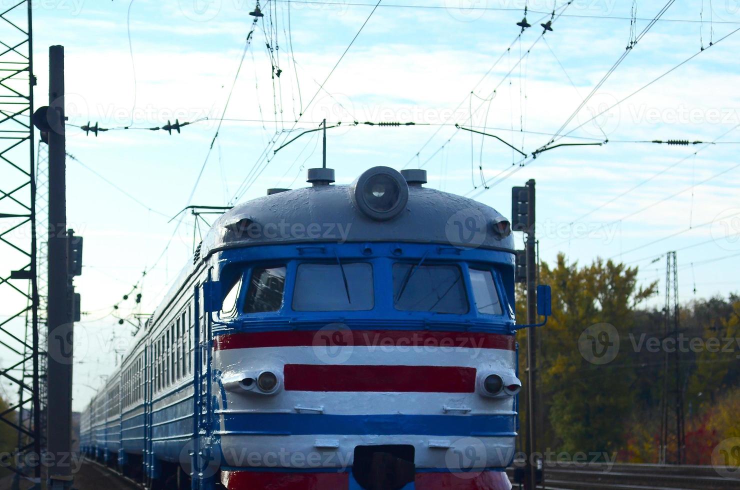 Old soviet electric train with outdated design moving by rail photo