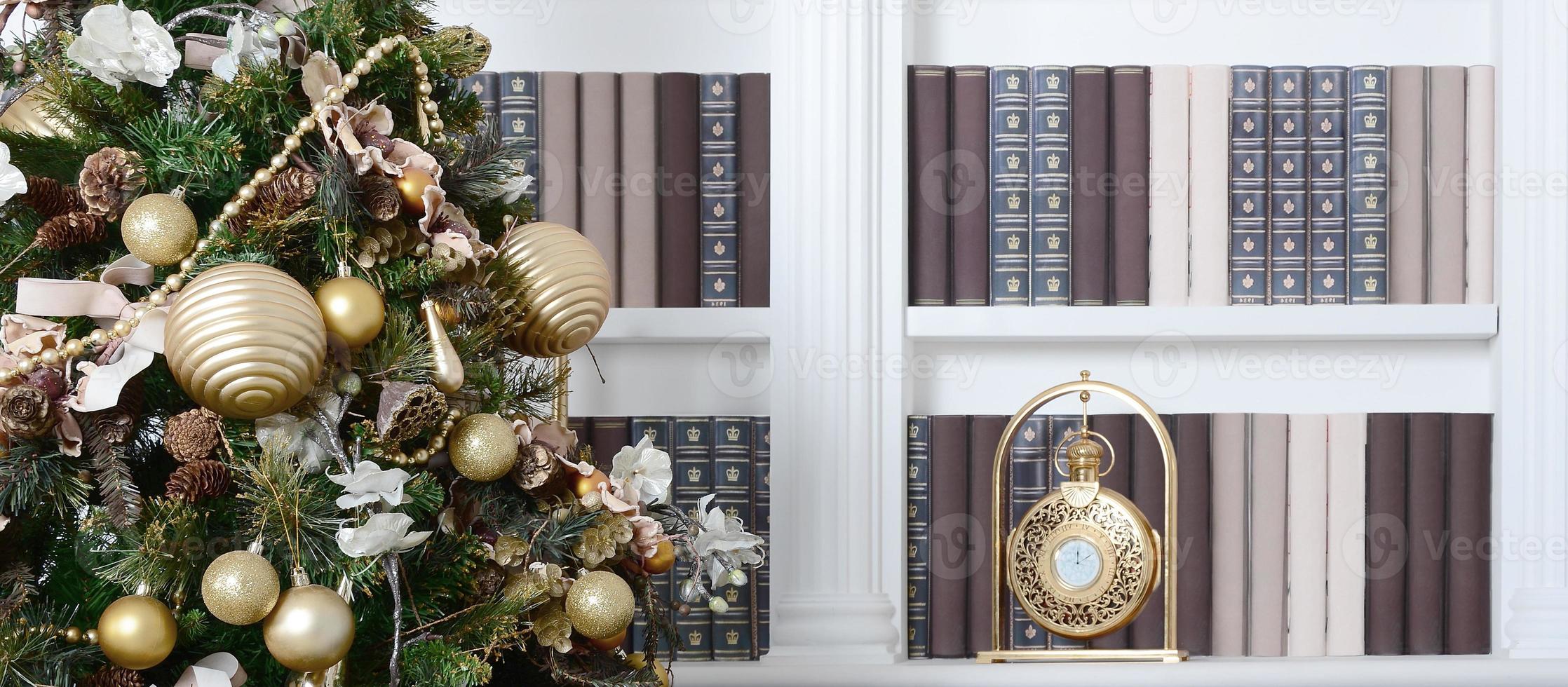 un hermoso árbol de navidad decorado en el fondo de una estantería con muchos libros de diferentes colores y un reloj dorado. imagen de fondo de navidad de la biblioteca foto