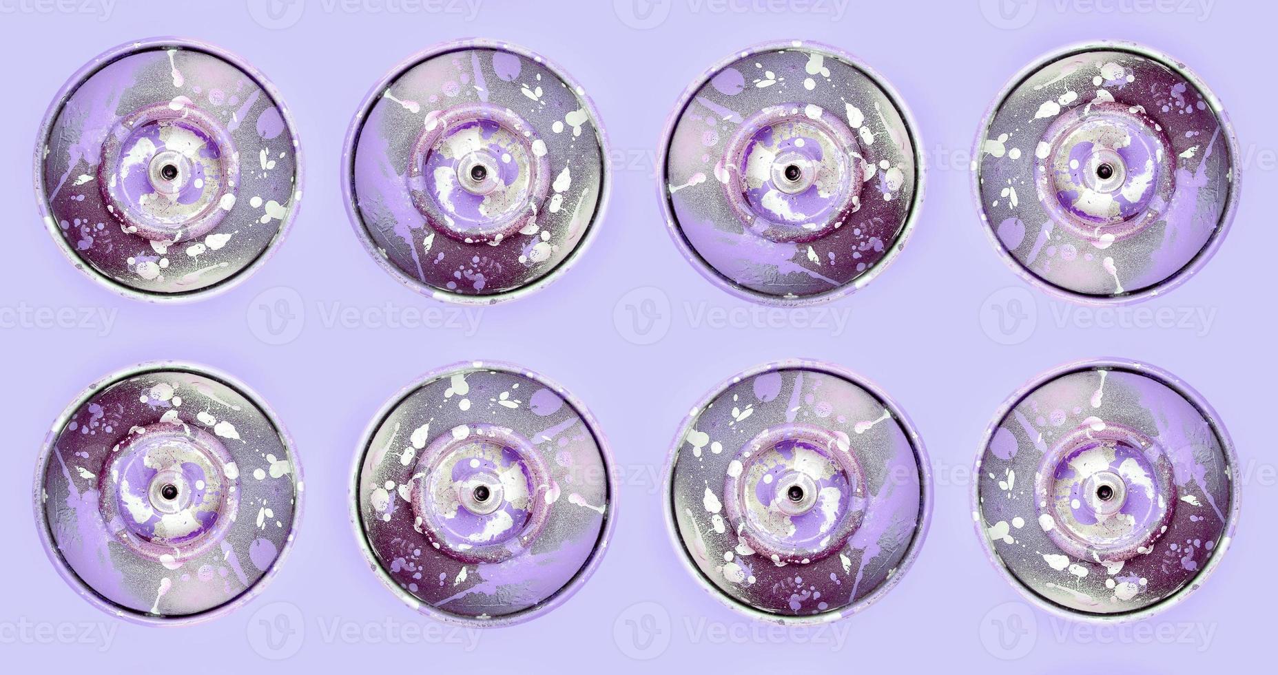 Many used spray cans for graffiti drawing lies on a pastel colored backgroung. Street art painting concept. Minimal flat lay pattern. Top view photo