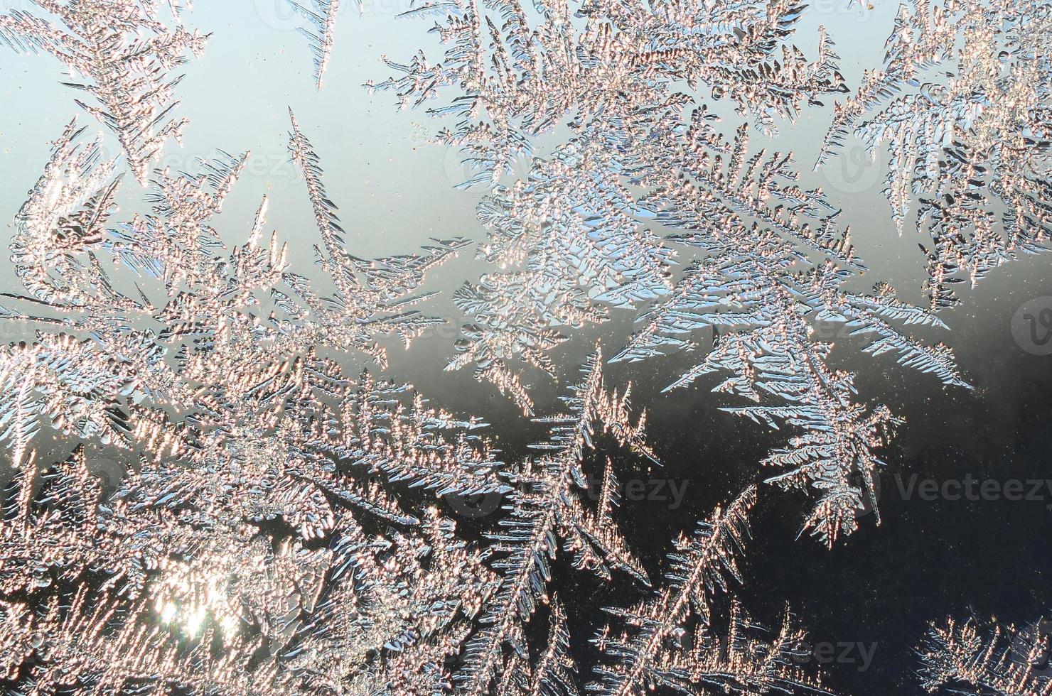 Snowflakes frost rime macro on window glass pane photo