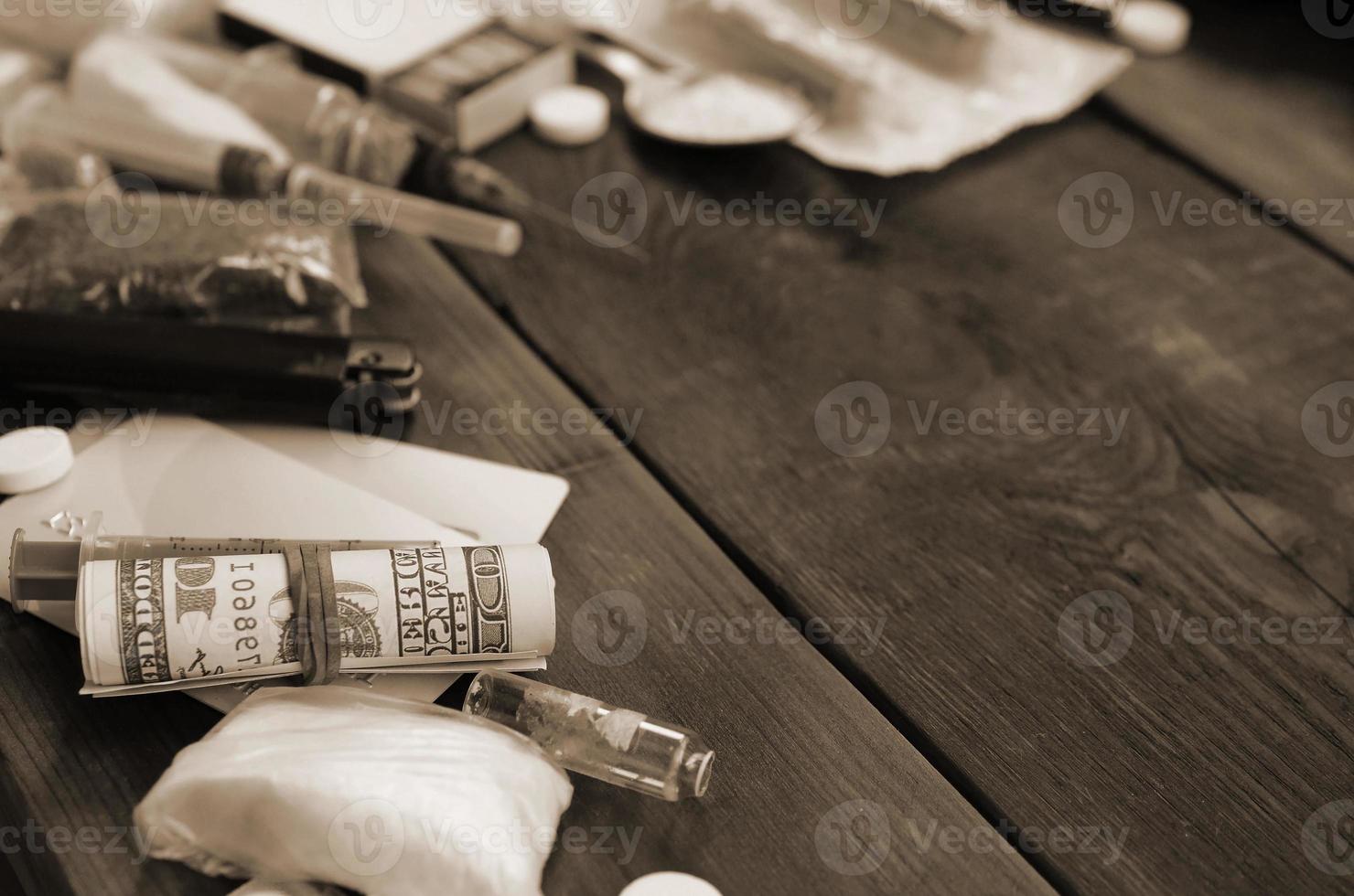 A lot of narcotic substances and devices for the preparation of drugs lie on an old wooden table photo