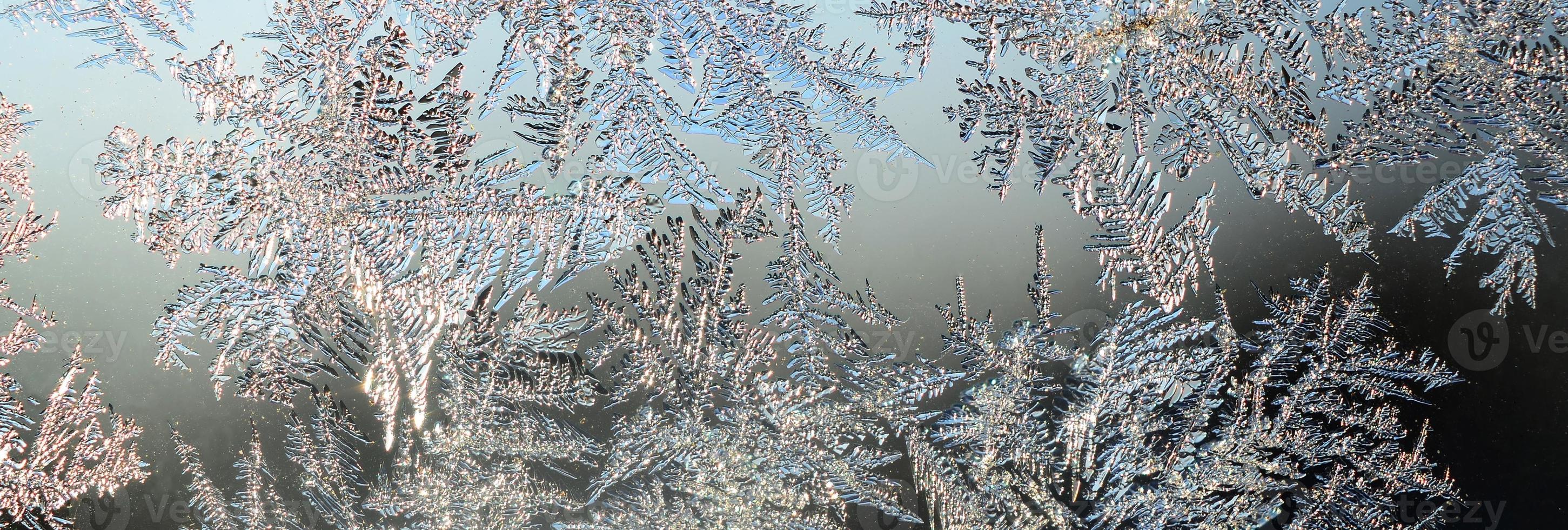 Snowflakes frost rime macro on window glass pane photo