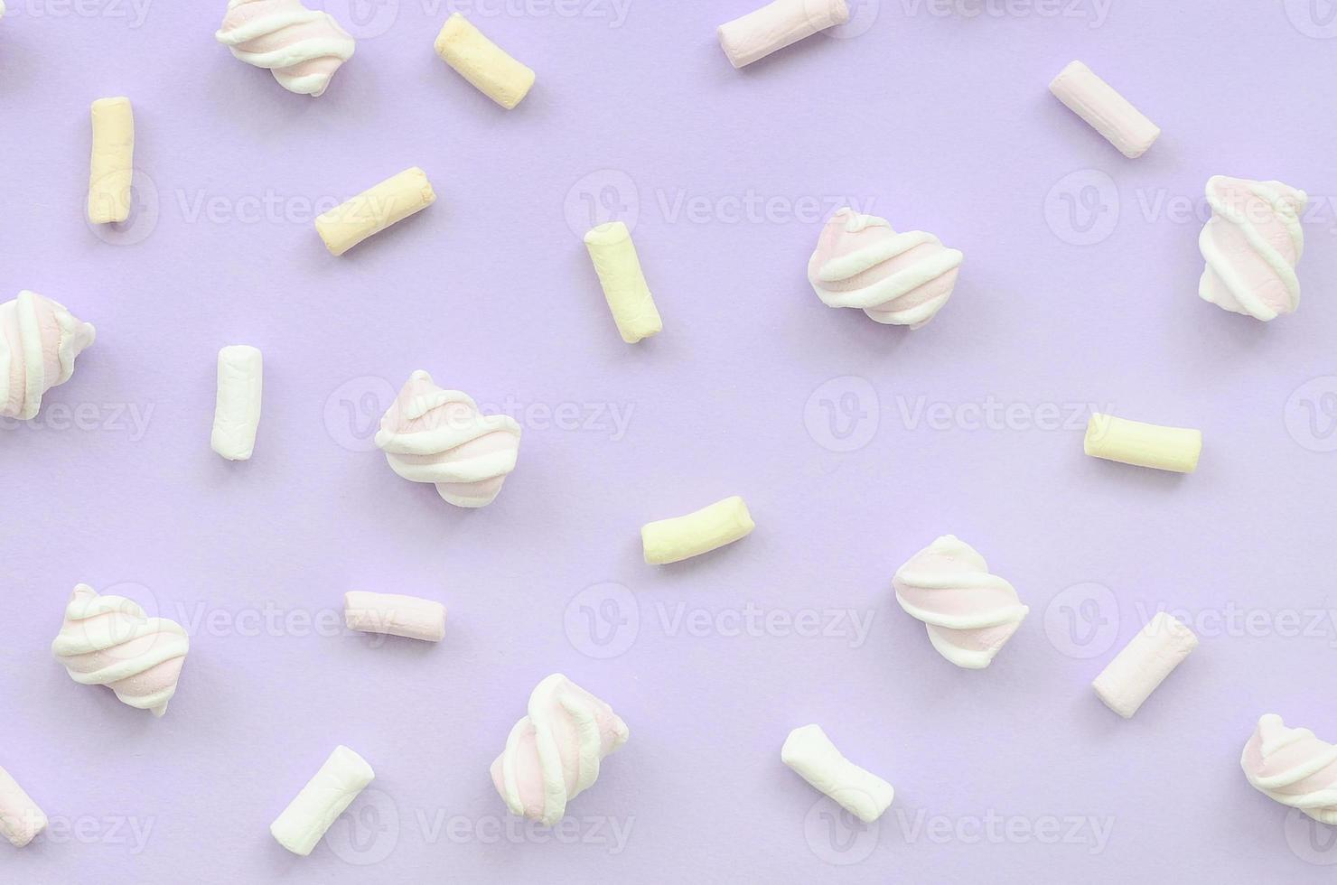 Colorful marshmallow laid out on violet paper background. pastel creative texture. minimal photo