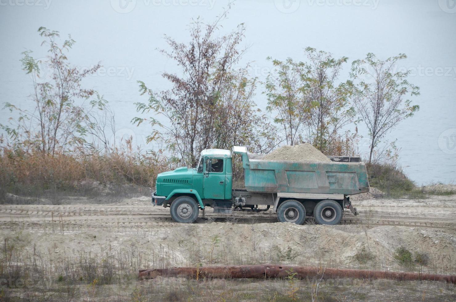 Dump truck transports sand and other minerals in the mining quarry. Heavy industry photo