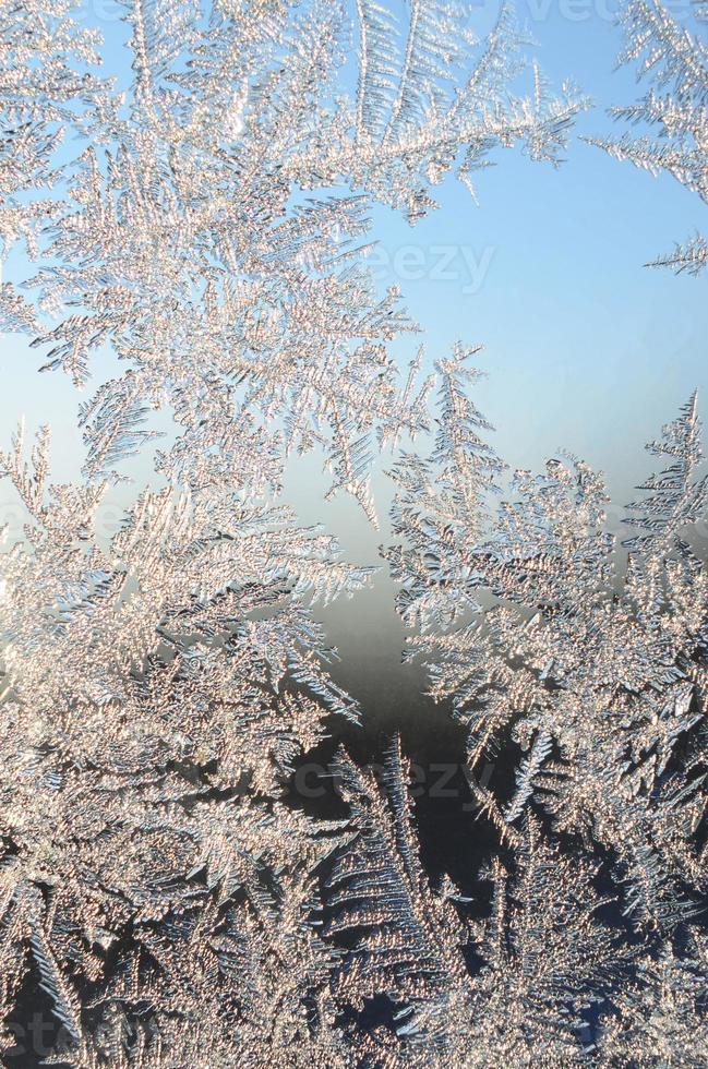 Snowflakes frost rime macro on window glass pane photo