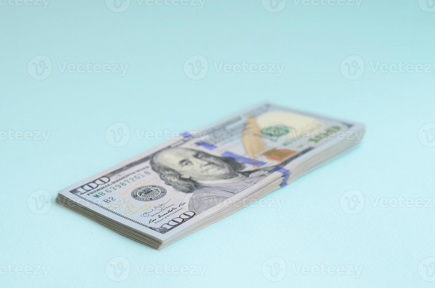 US dollar bills of a new design with a blue stripe in the middle is lies on a light blue background photo