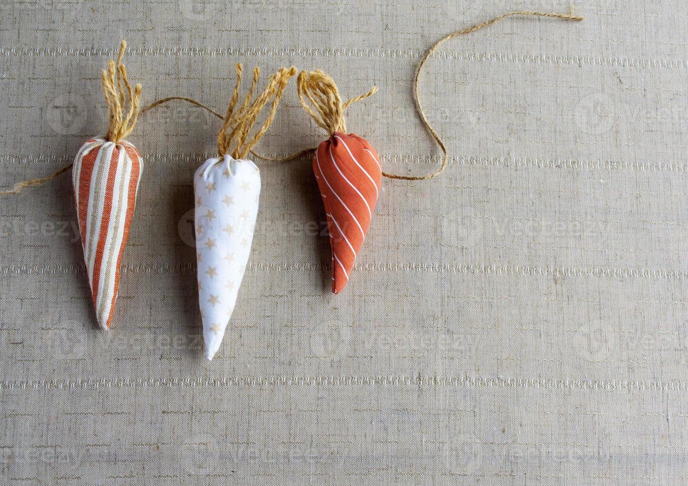 Easter banner. Carrots made of cotton fabric,  Easter home decor. The concept of a holiday, hobby, sewing and needlework. photo