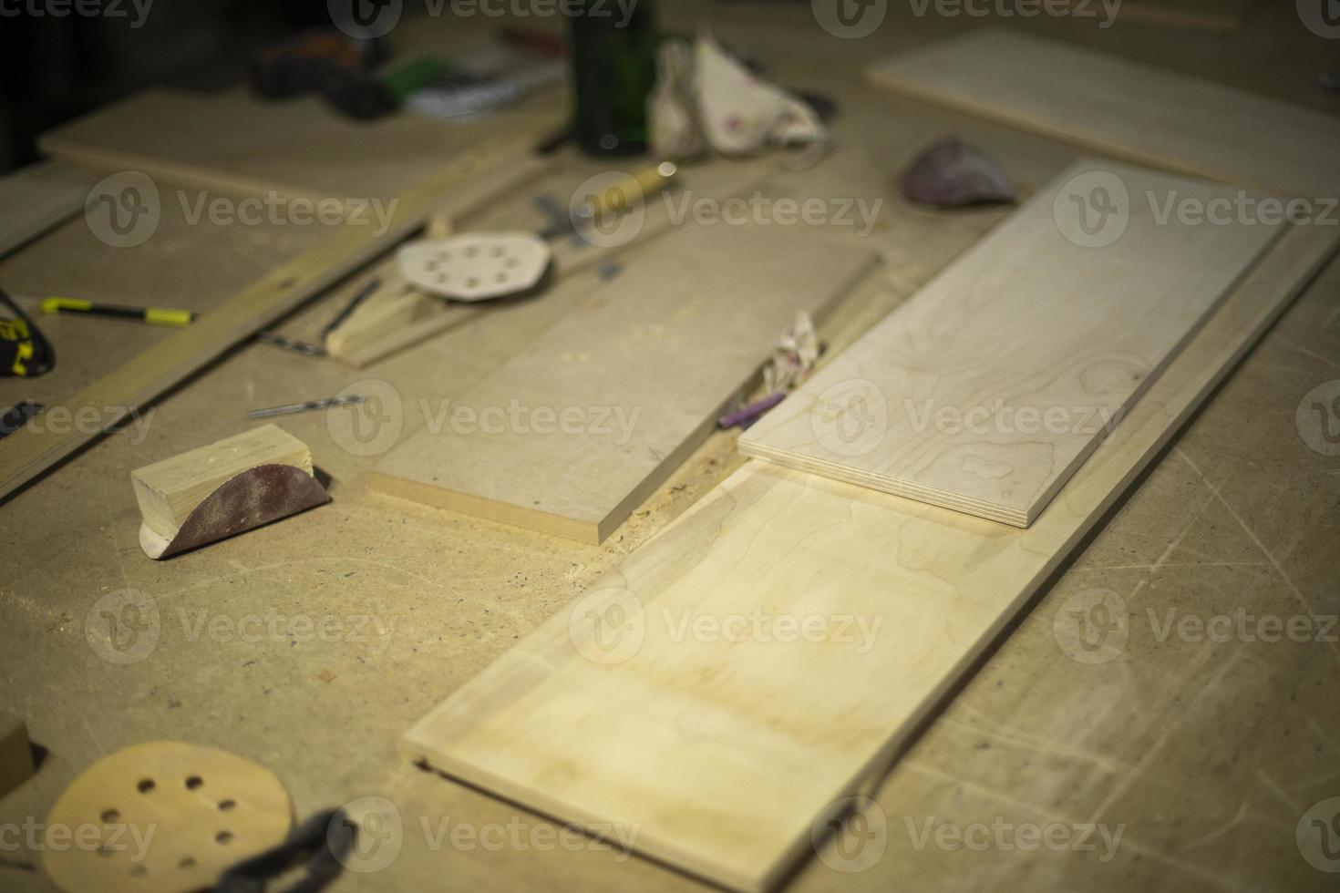 Boards on table. Details of carpentry workshop. Process of creating furniture. Things in garage. photo